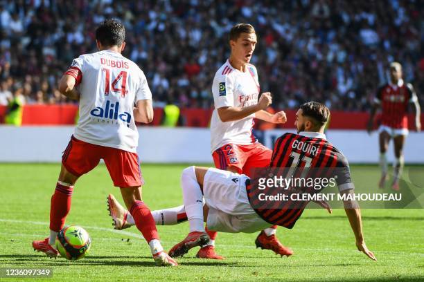 Nice's French forward Amine Gouiri fights for the ball with Lyon's French defender Leo Dubois and Lyon's French midfielder Maxence Caqueret during...