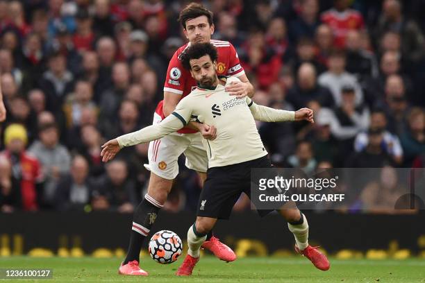 Liverpool's Egyptian midfielder Mohamed Salah vies with Manchester United's English defender Harry Maguire during the English Premier League football...