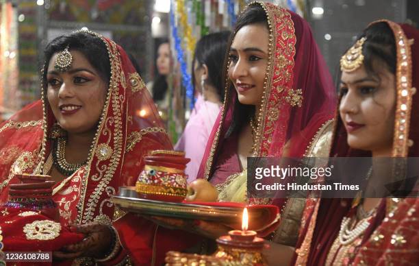 Women perform traditional Pooja on the occasion of Karva Chauth at Sector 20 Temple on October 24, 2021 in Chandigarh, India. Karwa Chauth falls on...