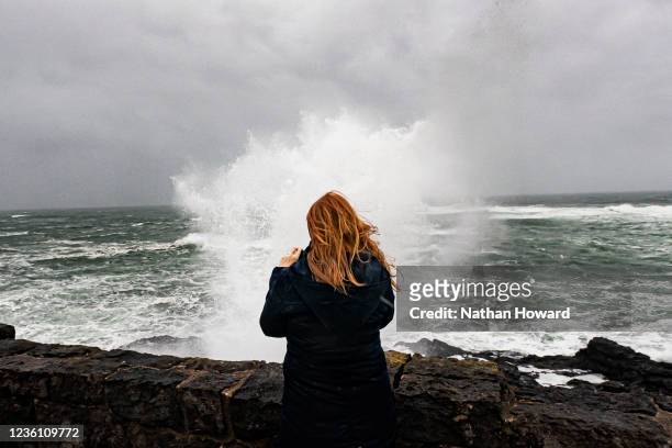 Storm watcher films heavy waves caused by a bomb cyclone system as they break against a sea wall on October 24, 2021 in Depoe Bay, Oregon. Heavy rain...