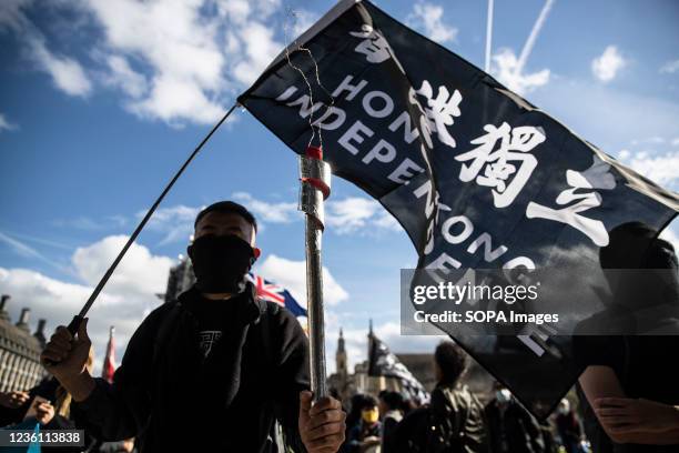 Representative from Hong Kong holds an Olympic torch replica and the Hong Kong Independent flag during the demonstration. A rally organised by six...