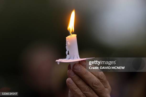 Man holds a candle during a candlelight vigil for cinematographer Halyna Hutchins, who was accidentally killed by a prop gun fired by actor Alec...