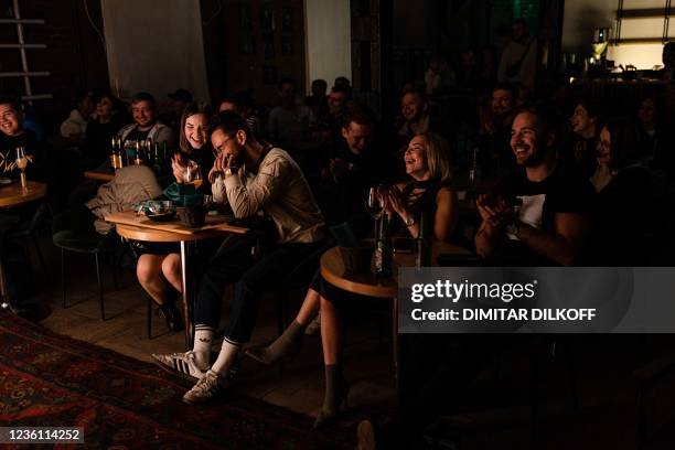 Members of the audience react while Russian standup comedian Pavel Dedishchev performs on stage in the loft of a Moscow bar on October 10, 2021. -...