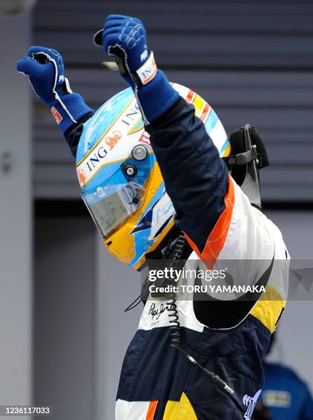 Spain's Fernando Alonso of Renault raises his arms in joy just after his victory in Formula One's Japanese Grand Prix at the Fuji Speedway, some 100...