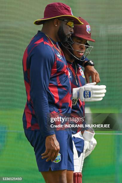 West Indies' Kieron Pollard speaks with teammate Shimron Hetmyer during a practice session ahead of the ICC men's Twenty20 World Cup cricket match...