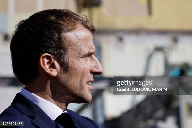 French President Emmanuel Macron looks on as he visits the "Gege" industrial wasteland, site of former French toy manufacturer "GeGe", in Montbrison,...