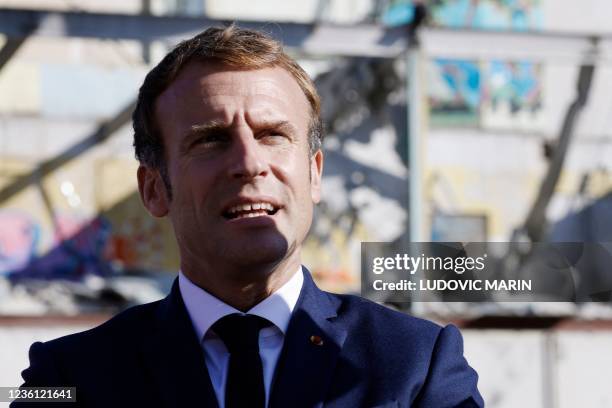 French President Emmanuel Macron looks on as he visits the "Gege" industrial wasteland, site of former French toy manufacturer "GeGe", in Montbrison,...