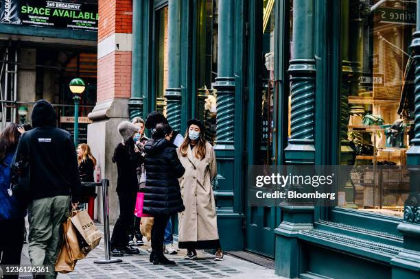 Shoppers wait in line to enter the Prada store in the SoHo neighborhood of New York, U.S., on Sunday, Oct. 24, 2021. Consumers are facing dire...