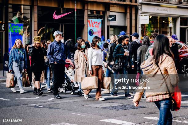 Pedestrians carry shopping bags in the SoHo neighborhood of New York, U.S., on Sunday, Oct. 24, 2021. Consumers are facing dire warnings to get...