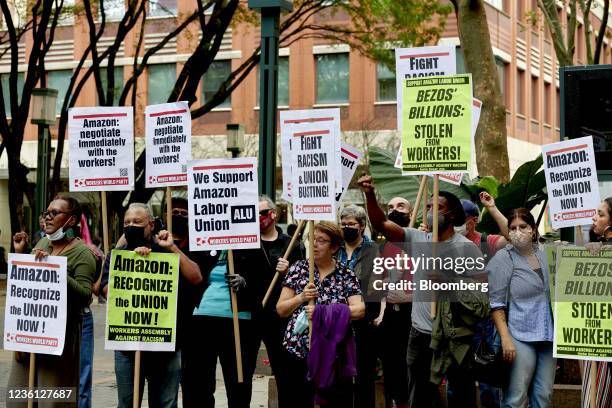 Workers and supporters hold signs after filing a petition requesting an election to form a union outside the National Labor Relations Board regional...