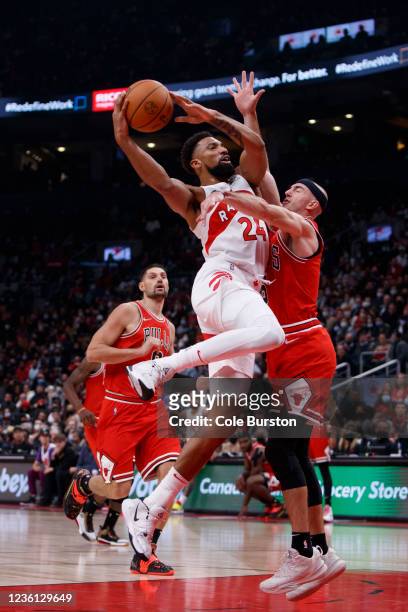 Khem Birch of the Toronto Raptors drives to the net against Alex Caruso of the Chicago Bulls during the first half at Scotiabank Arena on October 25,...