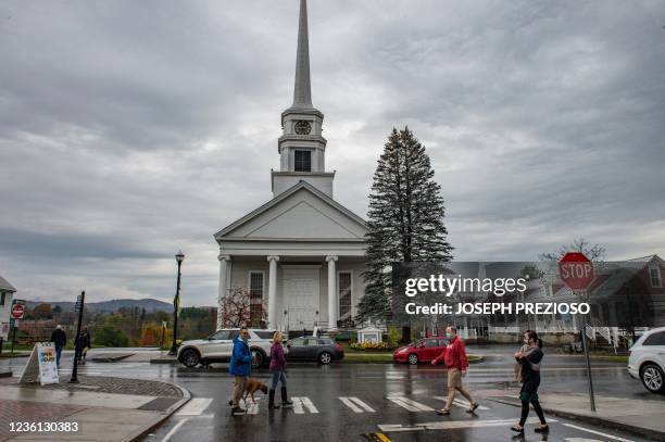 Ryan and Jennifer Cashman, and their dog Nova, walk to pick up their kids from school after grabbing coffee downtown in Stowe, Vermont on October 21,...