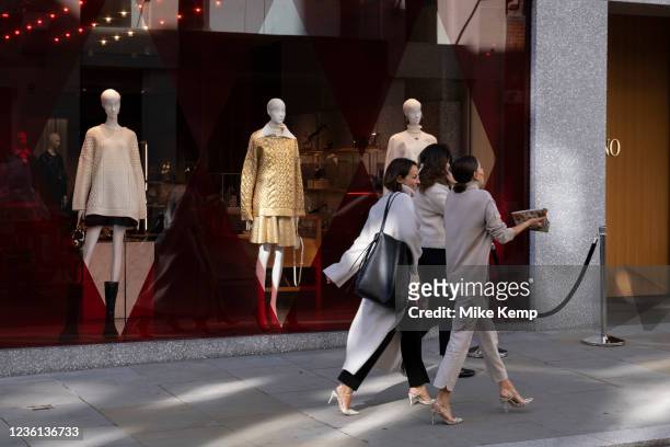 Fashionably dressed women pass a Bond Street shop window display containing mannequins with very thin legs on 20th October 2021 in London, United...
