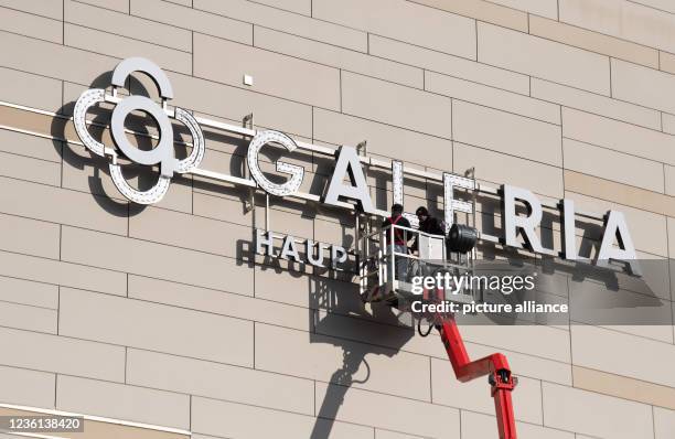 October 2021, Hessen, Frankfurt/Main: Workers install the new "Galeria" logo on the façade of the store at the Hauptwache in Frankfurt. The Galeria...