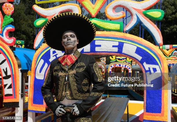 Actors characterized as skulls poses front a Trajinera on the occasion of celebrating the Mexican traditions of Day of the Dead celebrations known in...