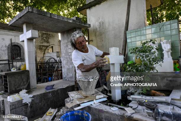 Gravestone maker prepares a stone ahead of the Day of The Dead celebration at the Ilustres Cemetery on October 26, 2021 in San Salvador, El Salvador.