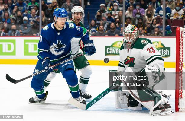 Alex Chiasson of the Vancouver Canucks and Jared Spurgeon of the Minnesota Wild eye the loose puck after goalie Cam Talbot of the Minnesota Wild made...