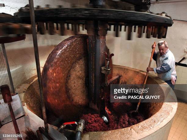 Un oléiculteur mélange la pulpe d'olive et l'eau, le 04 décembre 2003, dans un moulin du XVIIe siècle de Drap, un village sur les hauteurs de Nice,...