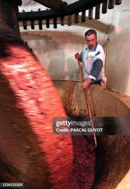 Un oléiculteur mélange la pulpe d'olive et l'eau, le 04 décembre 2003, dans un moulin du XVIIe siècle de Drap, un village sur les hauteurs de Nice,...