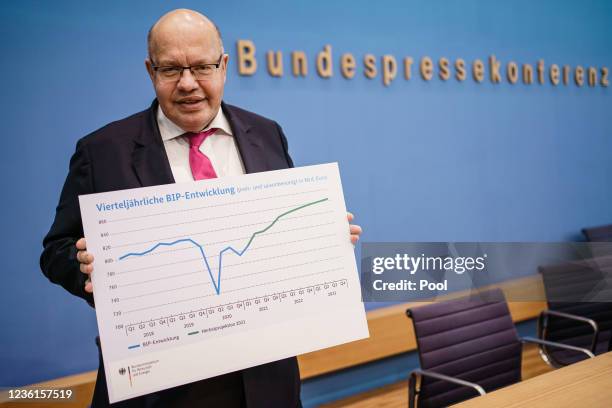 Acting German Minister of Economy and Energy Peter Altmaier poses with a graph showing the quarterly GDP development and the fall projection at the...