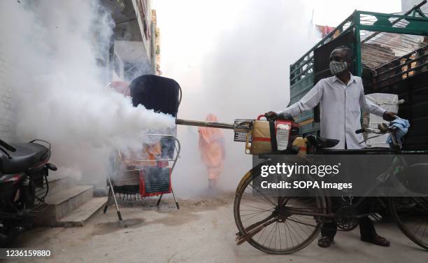 Fumigation worker wearing a mask fumigates inside a residential area as a precautionary measure against the spread of dengue disease as part of the...