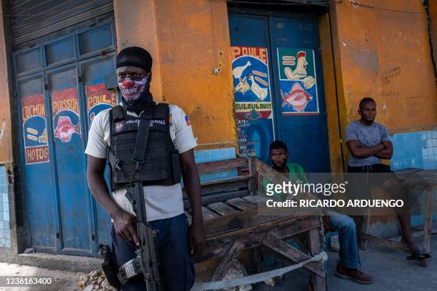 Haitian National Police officer stands guard close to the gang controlled area of Morne A Tuff during the third day of a general strike and lack of...