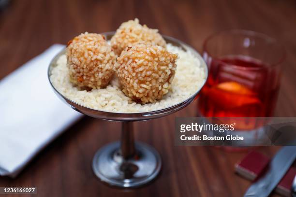 Cambridge, MA Saffron Suppli, crispy arborio rice, soft cheeses and abruzzese saffron served with Negroni at Bar Enza at the Charles Hotel in...
