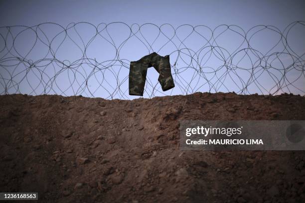 Pair of trousers of an Afghan Army soldier hangs out to dry over barbed wire, at the US Marine base of 3rd Battalion, 6th Marines, in Marjah, Helmand...