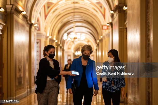 Sen. Elizabeth Warren walks on the Senate Side of the U.S. Capitol Building while speaking with a reporter on Wednesday, Oct. 27, 2021 in Washington,...