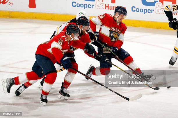 Patric Hornqvist and teammate Frank Vatrano of the Florida Panthers battle Trent Frederic of the Boston Bruins for possession during the second...