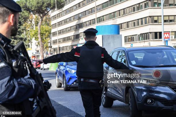 Carabinieri police officers divert motorists at a checkpoint outside the convention center "La Nuvola" on October 28, 2021 in the EUR district of...