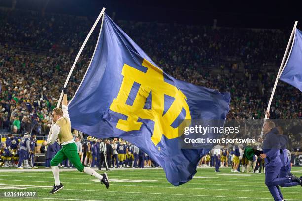 The Notre Dame Fighting Irish mascot the Leprechaun is seen running with a Notre Dame Fighting Irish flag during a game between the USC Trojans and...