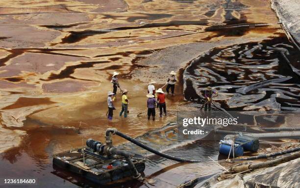 Workers drain away polluted water near the Zijin copper mine in Shanghang on July 13 after pollution from the mine contaminated the Ting river, a...