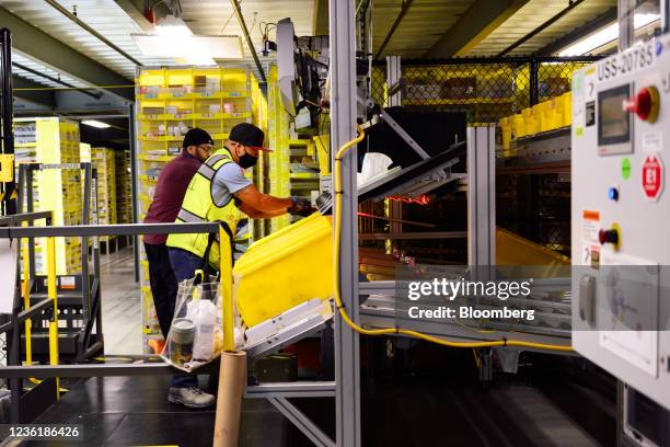 Workers prepare orders for shipment at the Amazon.com BFI4 fulfillment center in Kent, Washington, U.S., on Thursday, Aug. 5, 2021. August 4, 2021....