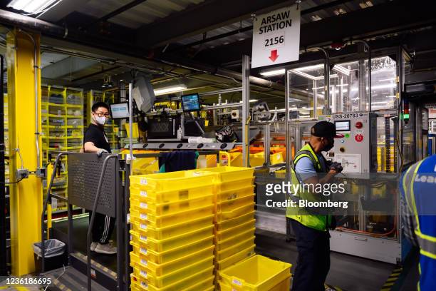 Workers at the Amazon Robotics Semi-Automatic Workstation at the company's BFI4 fulfillment center in Kent, Washington, U.S., on Thursday, Aug. 5,...