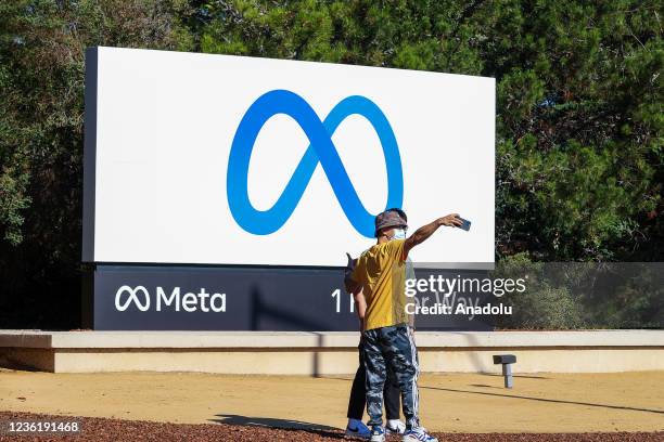 People take photos with the new "Meta" sign at the One Hacker Way in Menlo Park, as Facebook changes its company name to Meta in California, United...