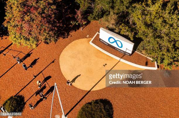 An aerial view shows a person passing a newly unveiled logo for "Meta", the new name for Facebook's parent company, outside Facebook headquarters in...