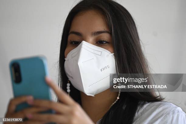 Marta Morales uses her cell phone during a virtual class in the Forever Foundation in Soyapango, El Salvador on October 19, 2021. - Marta, who lives...