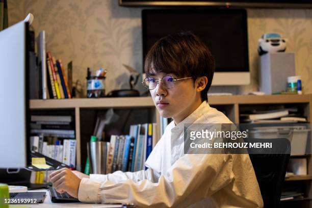 This photo taken on October 22, 2021 shows Shoma Motegi, a student and a member of the Japan Youth Conference NGO, working on his projects at his...