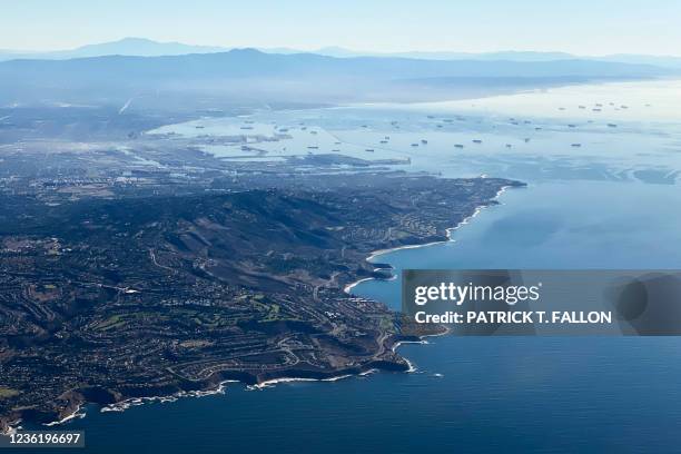 An aerial image taken on October 28, 2021 shows the Palos Verdes Peninsula and cargo container ships waiting in the Pacific Ocean to unload at the...