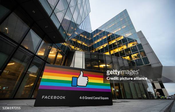 October 2021, Ireland, Dublin: A "Like hand" against a rainbow background stands outside Facebook's European headquarters in the Docklands district...