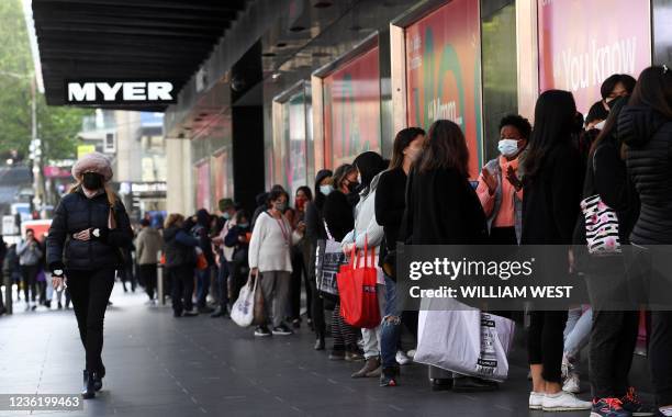 People queue outside a department store in Melbourne on October 29, 2021 as the city further lifts Covid restrictions allowing non-essential retail...