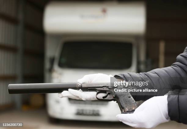 October 2021, North Rhine-Westphalia, Meckenheim: An employee of the Federal Criminal Police Office holds one of the murder weapons, a Ceska 83, 7.65...