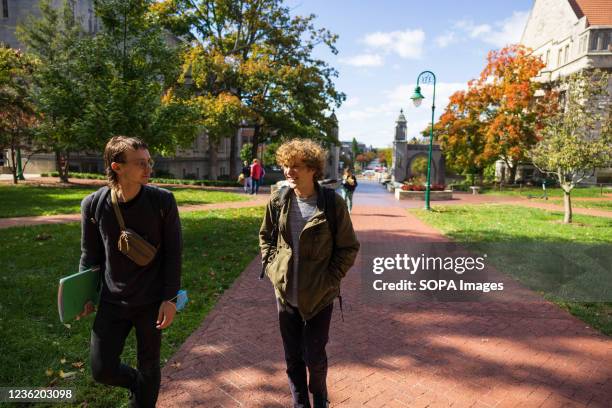 Indiana Grad Workers Coalition organizers Cole Nelson and Pat Wall walk across campus to a science building to sign graduate workers up with union...