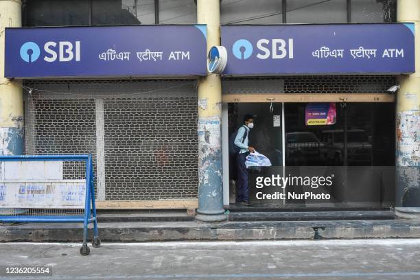 People exit an State bank of India ATM counter at a street in Kolkata , India , on 29 October 2021 . SBI profits jumped 67% in Q2 2021 to Rs 345...