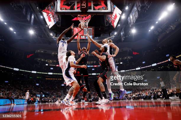 Dalano Banton of the Toronto Raptors battles for a rebound with Mo Bamba, Robin Lopez, and Cole Anthony of the Orlando Magic during the first half of...