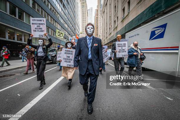 Participants dressed as masked bankers seen marching at the protest. Hundreds of New Yorkers still reeling from the effects of Hurricane Ida, marched...
