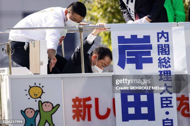 Japan's Prime Minister and leader of Liberal Democratic Party Fumio Kishida gets on atop a van to attend an election campaign in Saitama on October...