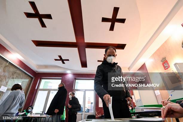 Man casts his ballot at a polling station in Tbilisi on October 30, 2021. - Georgia holds on October 30 second round runoffs in closely watched local...