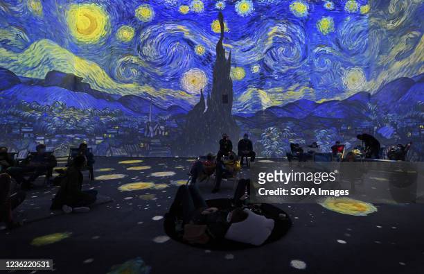 Museum-goers watch a projection mapping of Van Gogh's Starry Night during the show. Van Gogh The Immersive Experience is a Projection Mapping show in...